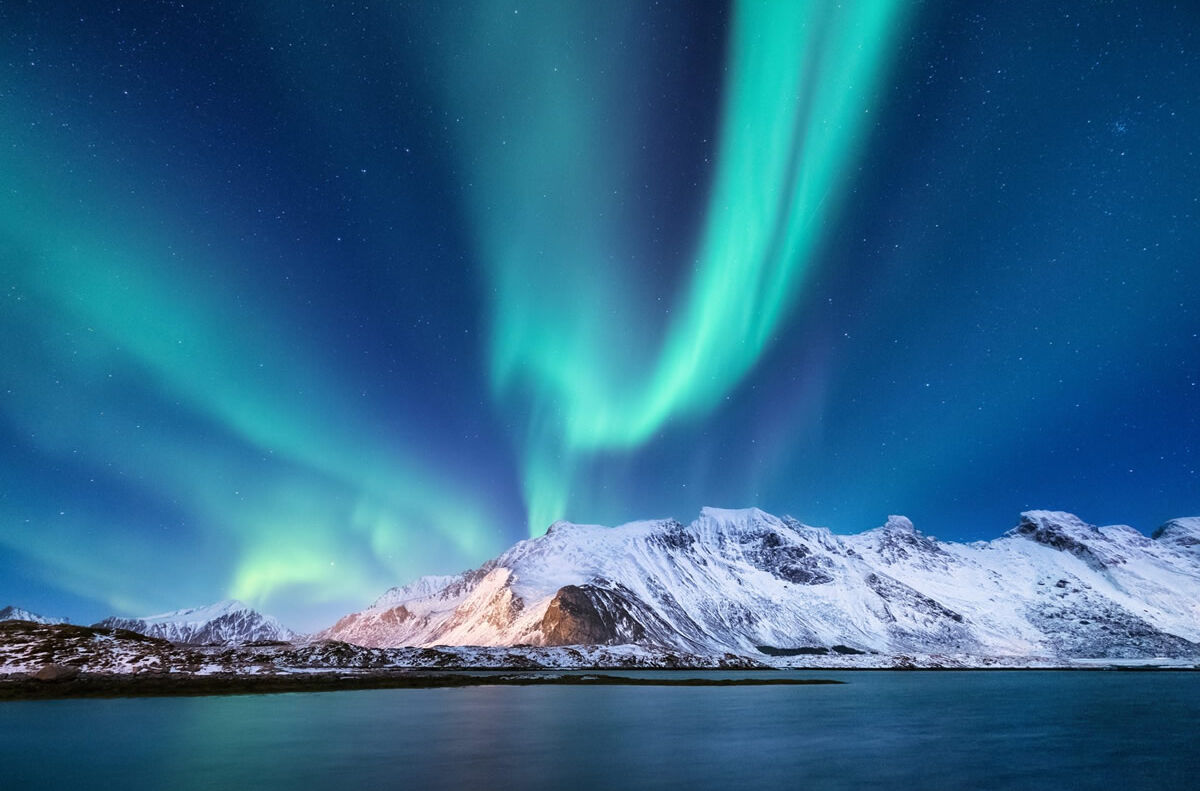 Nordlichter über verschneiten Bergen in Finnland