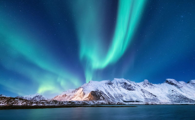 Nordlichter über verschneiten Bergen in Finnland
